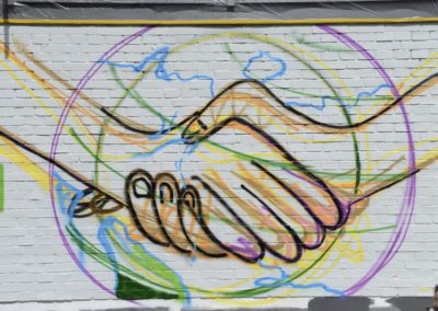 Schüler besprühen eine Wand mit Graffiti